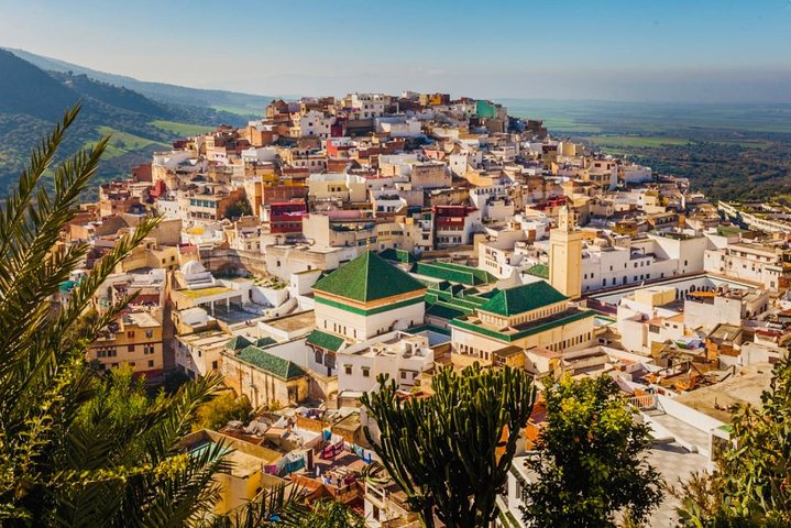 A panoramic view of the Fes Medina at sunset with minarets in the distance